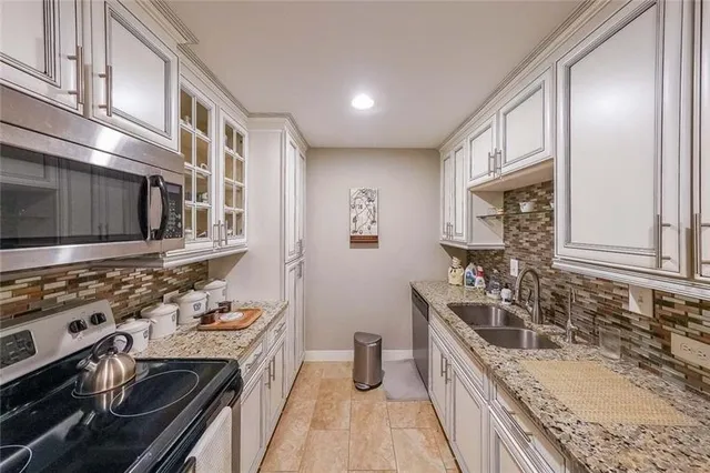 a kitchen with stainless steel appliances granite countertop a stove microwave refrigerator and cabinets