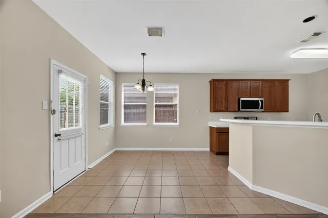 a view of an empty room with a kitchen