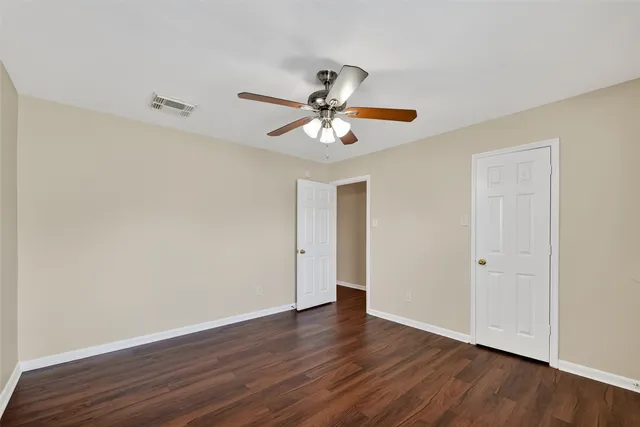 a view of a room with wooden floor and a ceiling fan