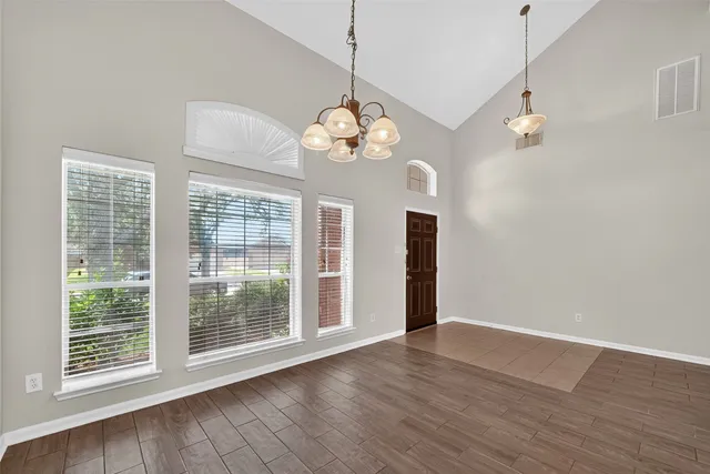 a view of a room with wooden floor chandelier and entryway