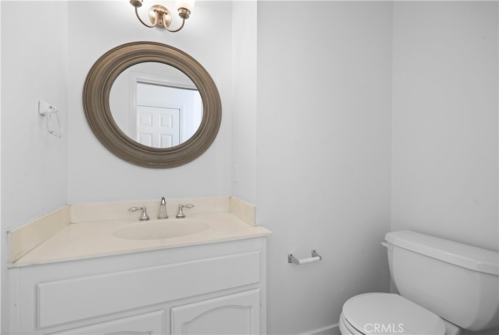 1597 Riverside Place Costa Mesa, CA 92627 - Photo 12 of 37 a bathroom with a toilet sink mirror and vanity