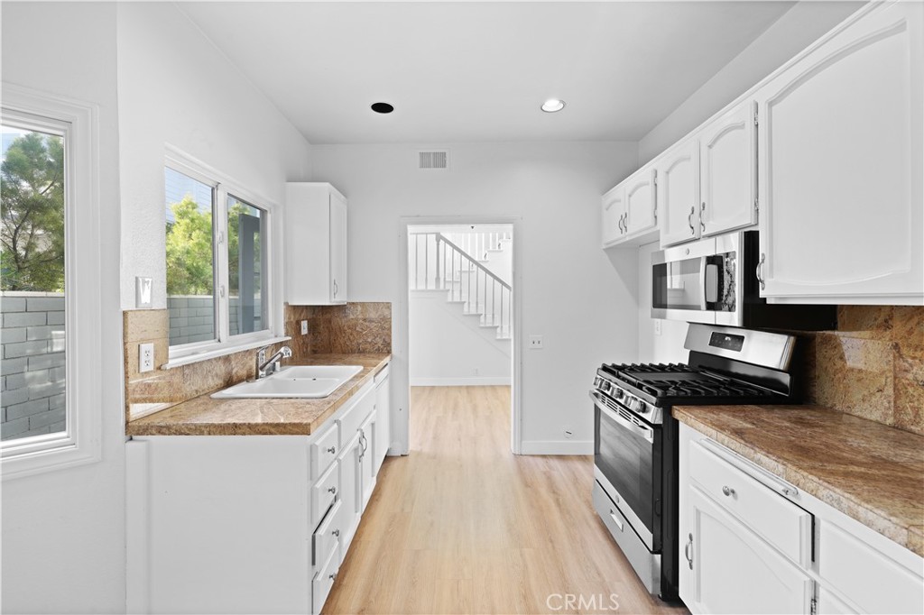1597 Riverside Place Costa Mesa, CA 92627 - Photo 15 of 37 a kitchen with stainless steel appliances granite countertop a sink stove and refrigerator
