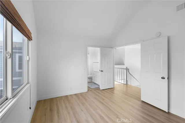 a view of empty room with wooden floor and white walls