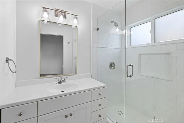 a bathroom with a shower sink and mirror