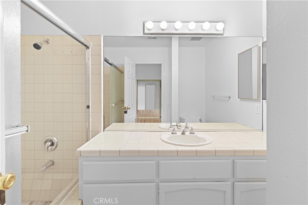 1597 Riverside Place Costa Mesa, CA 92627 - Photo 32 of 37 a bathroom with a sink a mirror and a shower