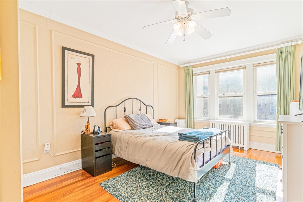 14 James Street, Unit 3 Brookline, MA 02446 - Photo 4 of 12 a bedroom with a bed and a chandelier