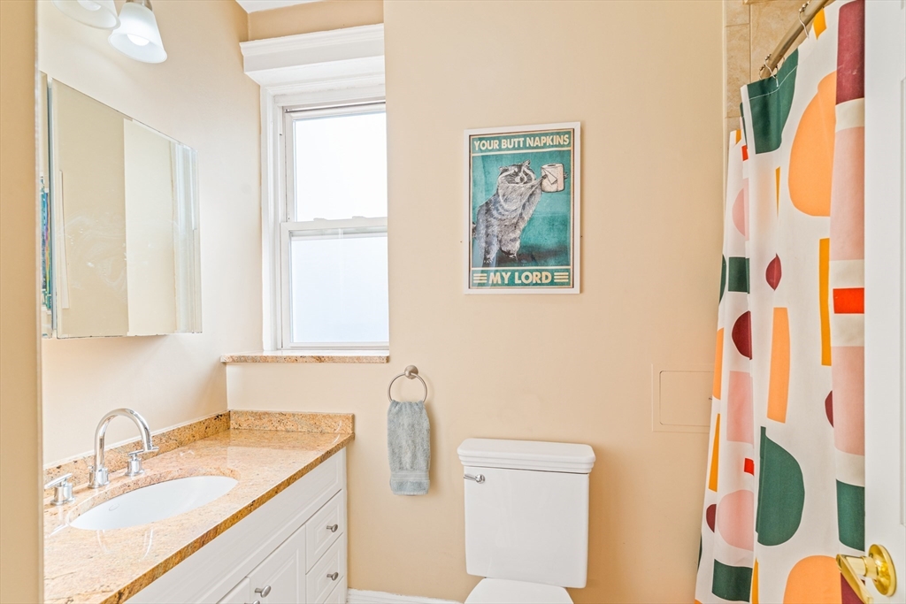 14 James Street, Unit 3 Brookline, MA 02446 - Photo 8 of 12 a bathroom with a granite countertop sink mirror vanity and toilet