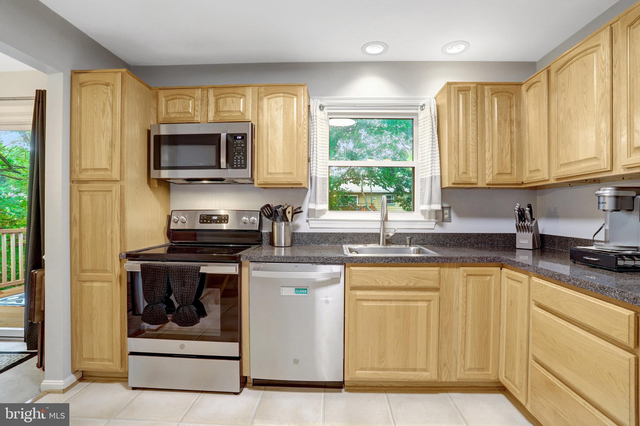 4518 Flintstone Road Alexandria, VA 22306 - Photo 21 of 62 a kitchen with stainless steel appliances granite countertop a stove a sink and a microwave