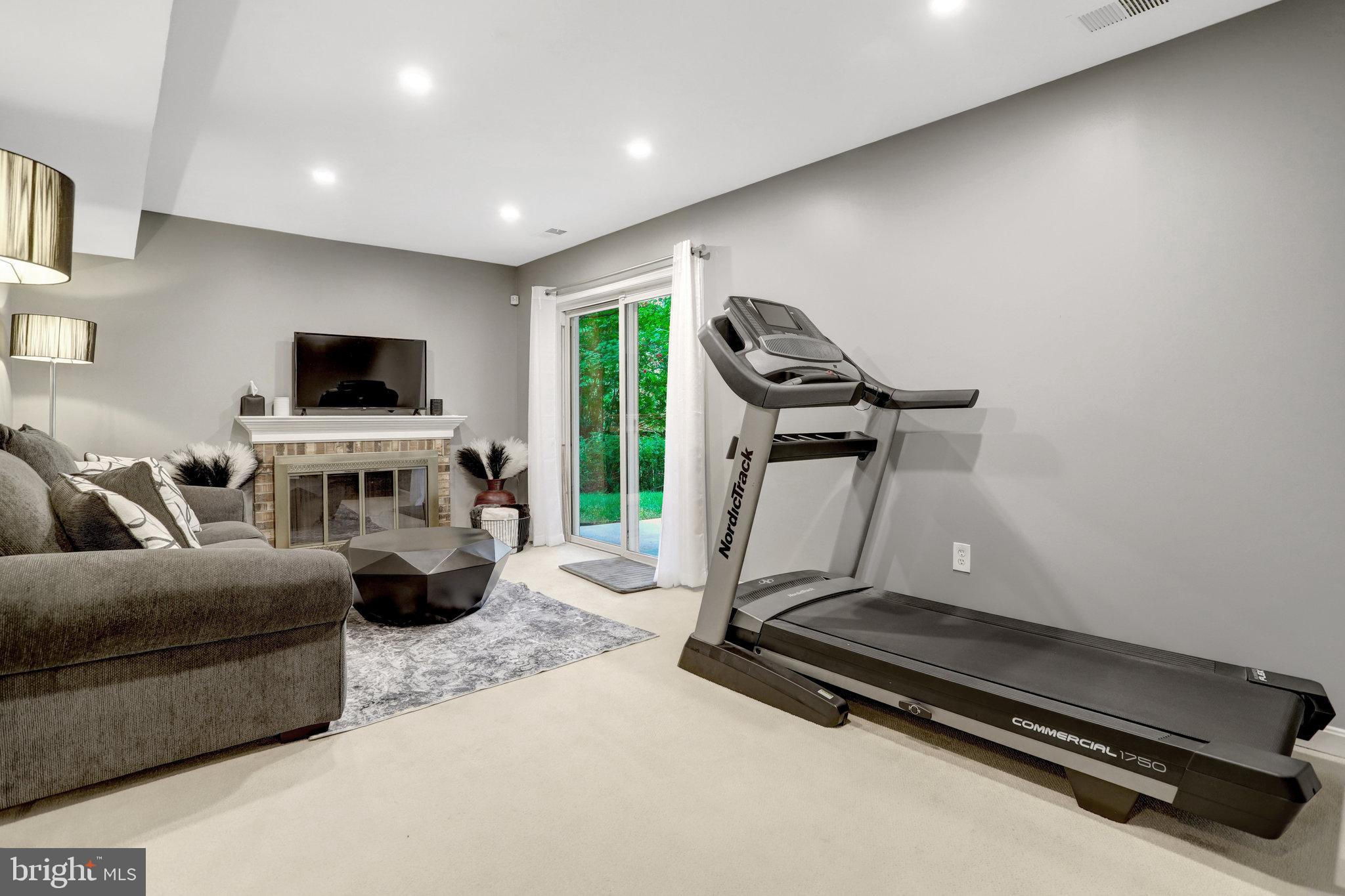 4518 Flintstone Road Alexandria, VA 22306 - Photo 38 of 62 a living room with furniture gym equipment and a flat screen tv
