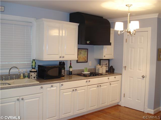 4025 Poplar Grove Road Midlothian, VA 23112 - Photo 7 of 12 a kitchen with a sink dishwasher and white cabinets with wooden floor