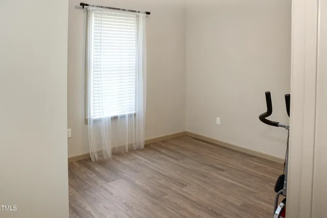 a view of a room that has wooden floor and a window