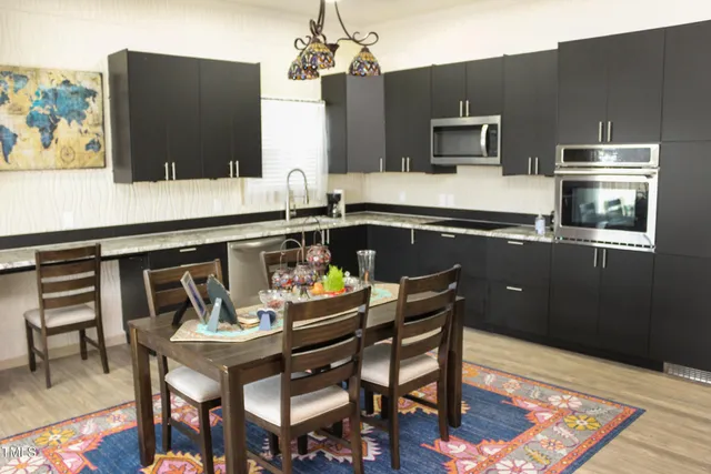 a kitchen with a table chairs refrigerator and microwave