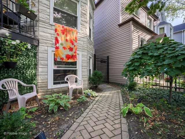 a front view of a house with garden and sitting area
