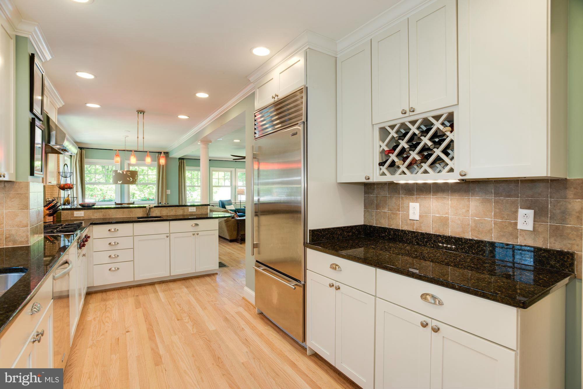 6224 30th Street Northwest Washington, DC 20015 - Photo 9 of 30 a kitchen with stainless steel appliances granite countertop a stove a sink and white cabinets with wooden floor