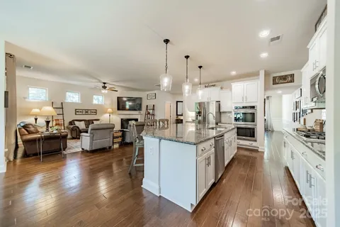 a large kitchen with stainless steel appliances kitchen island granite countertop a large counter top and stainless steel appliances