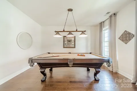 a room with pool table and windows