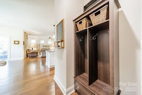 a view of a hallway with wooden floor and a living room
