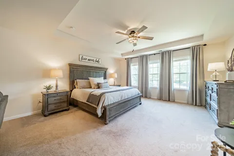a bedroom with a large bed and a chandelier