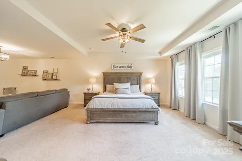 a spacious bedroom with a bed and a chandelier