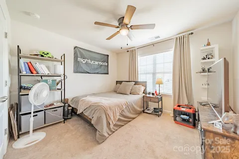 a bedroom with a bed a couch and a chandelier