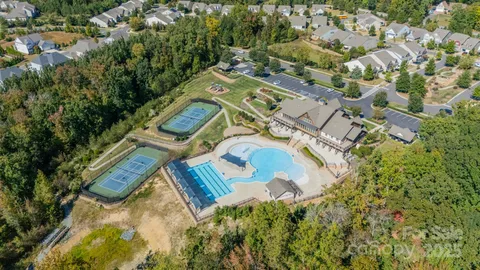 an aerial view of a house with a yard and greenery