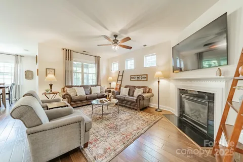 a living room with furniture a fireplace and a chandelier