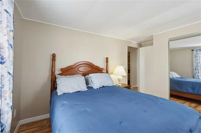 a bedroom with a bed and a closet with wooden floor