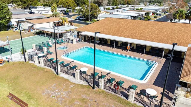 a view of a swimming pool with lawn chairs under an umbrella