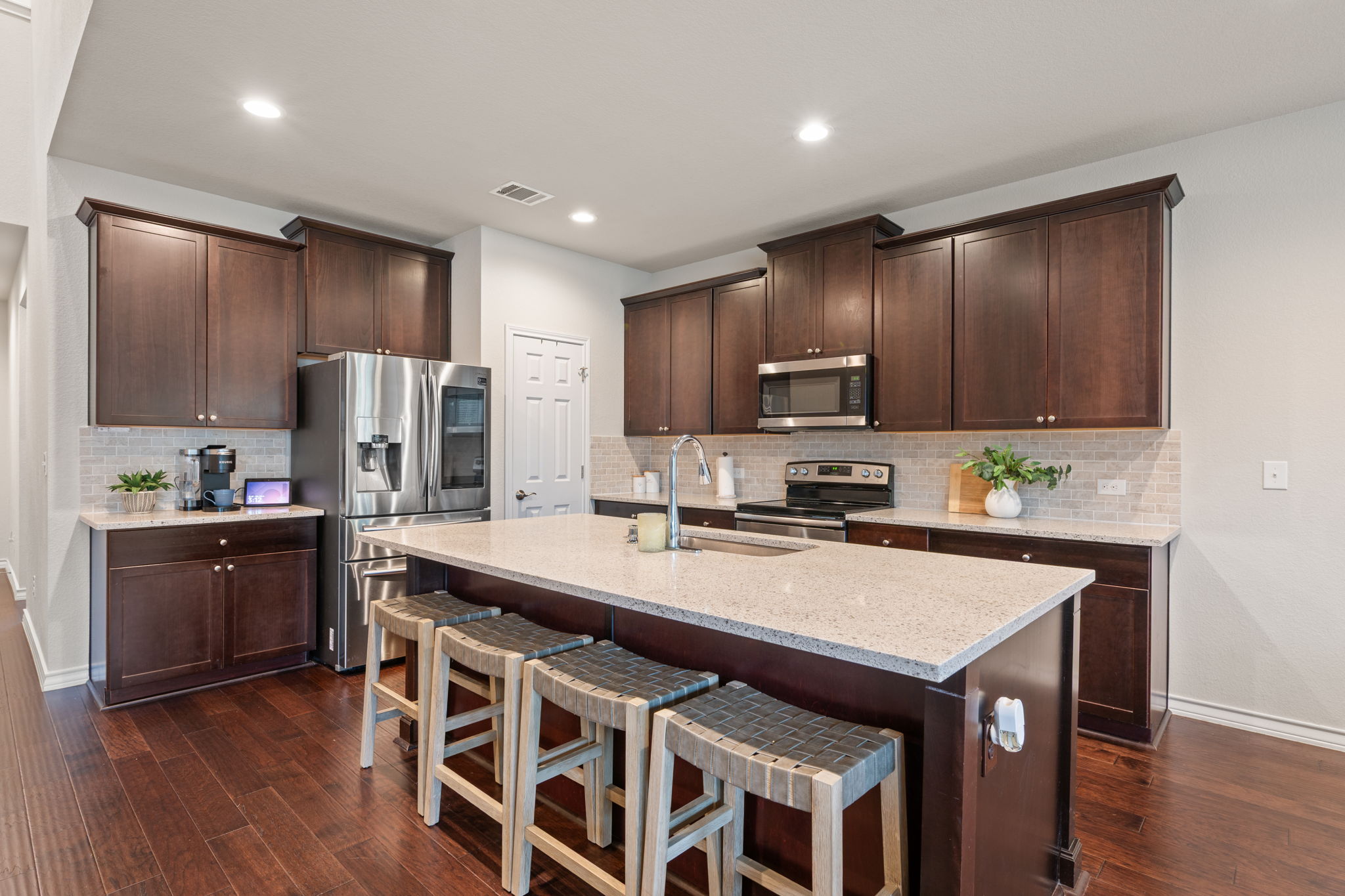 409 Limestone Road Liberty Hill, TX 78642 - Photo 7 of 35 a kitchen with stainless steel appliances a stove a sink a microwave a refrigerator and cabinets