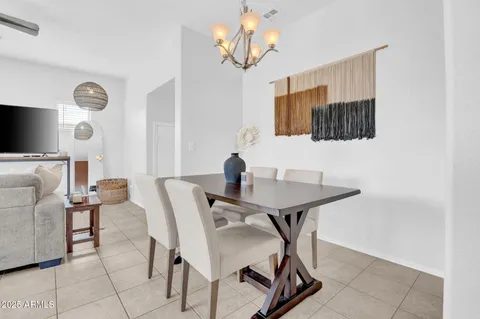 a kitchen with stainless steel appliances granite countertop a refrigerator a oven a sink a dining table and chairs with wooden floor