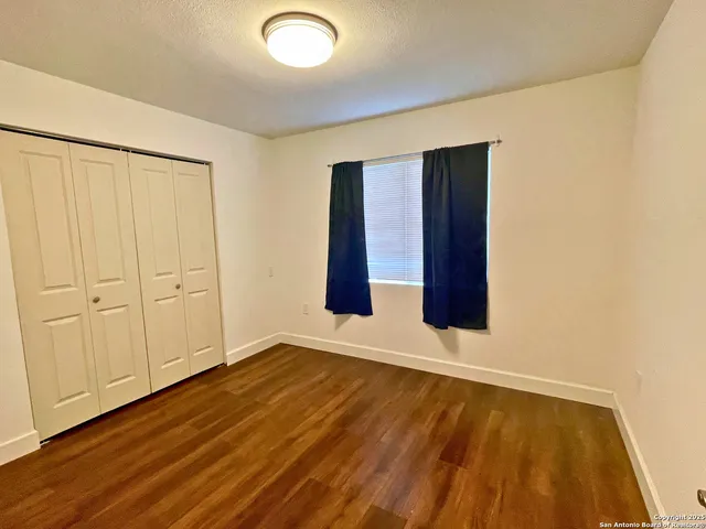 an empty room with wooden floor and closet