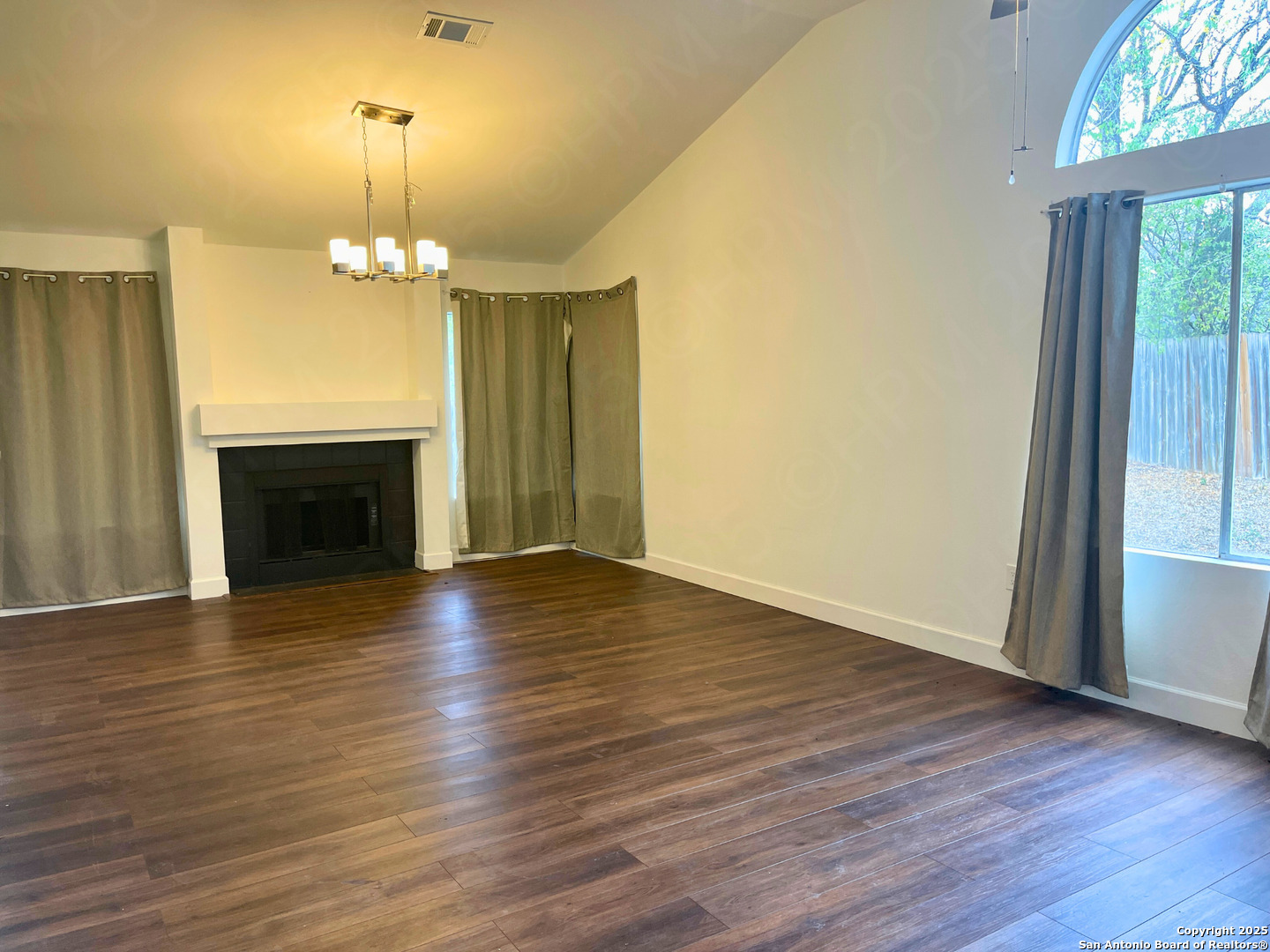 7727 Broken Arrow Converse, TX 78109 - Photo 4 of 17 an empty room with wooden floor fireplace and window