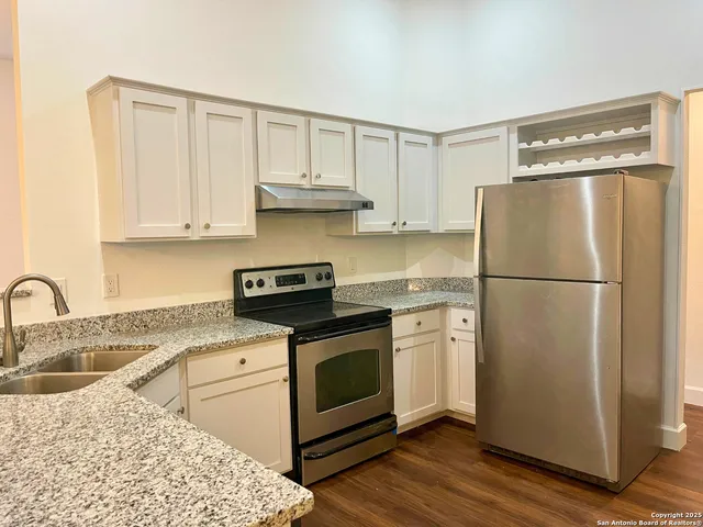 a kitchen with a refrigerator sink and cabinets