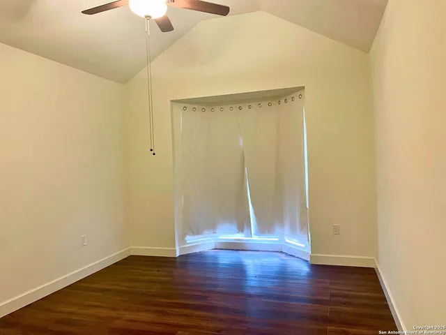 a view of an empty room with wooden floor