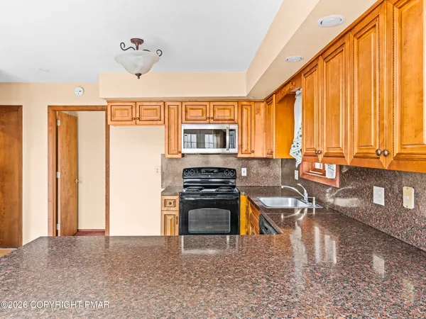 a kitchen with stainless steel appliances granite countertop a stove a sink dishwasher a microwave oven with granite countertops and cabinets