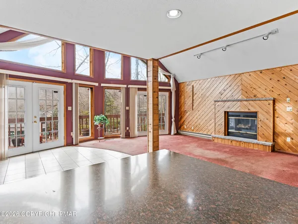 a view of an empty room with a fireplace and a window