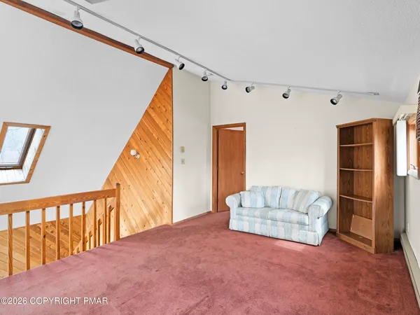 a view of a bedroom with wooden floor and a bed