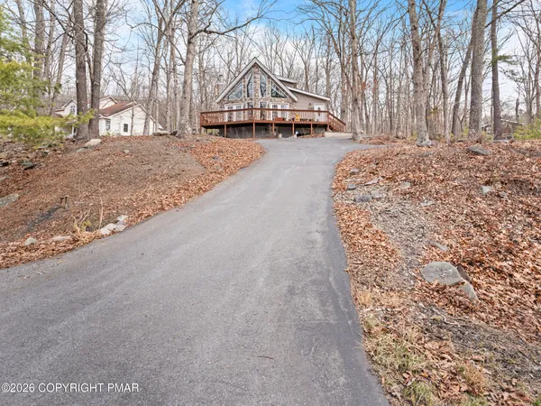 a front view of a house with a yard and trees
