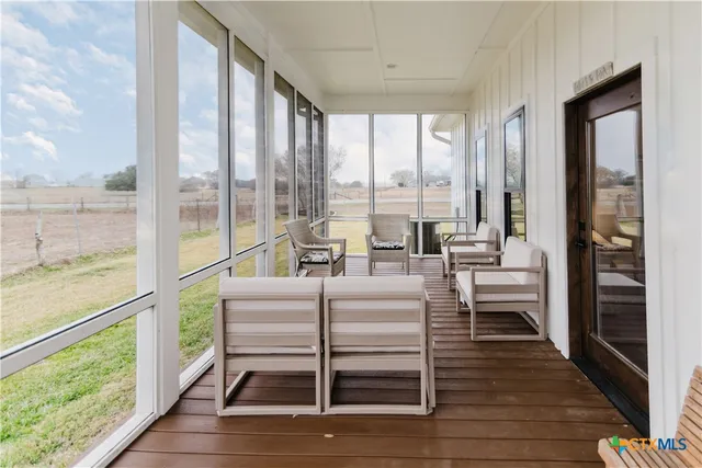 a living room with furniture and large windows