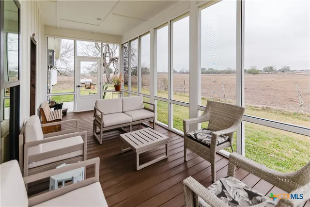 a living room with furniture and a floor to ceiling window