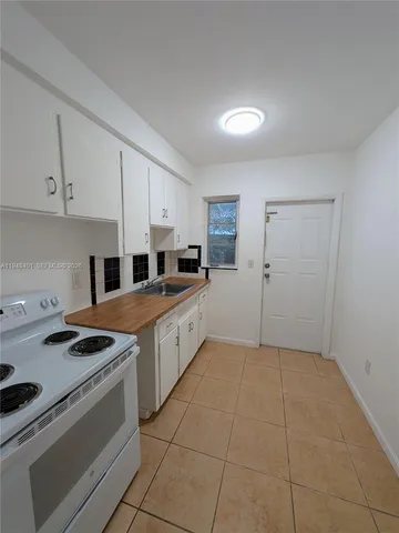 a kitchen with a stove a sink and a refrigerator