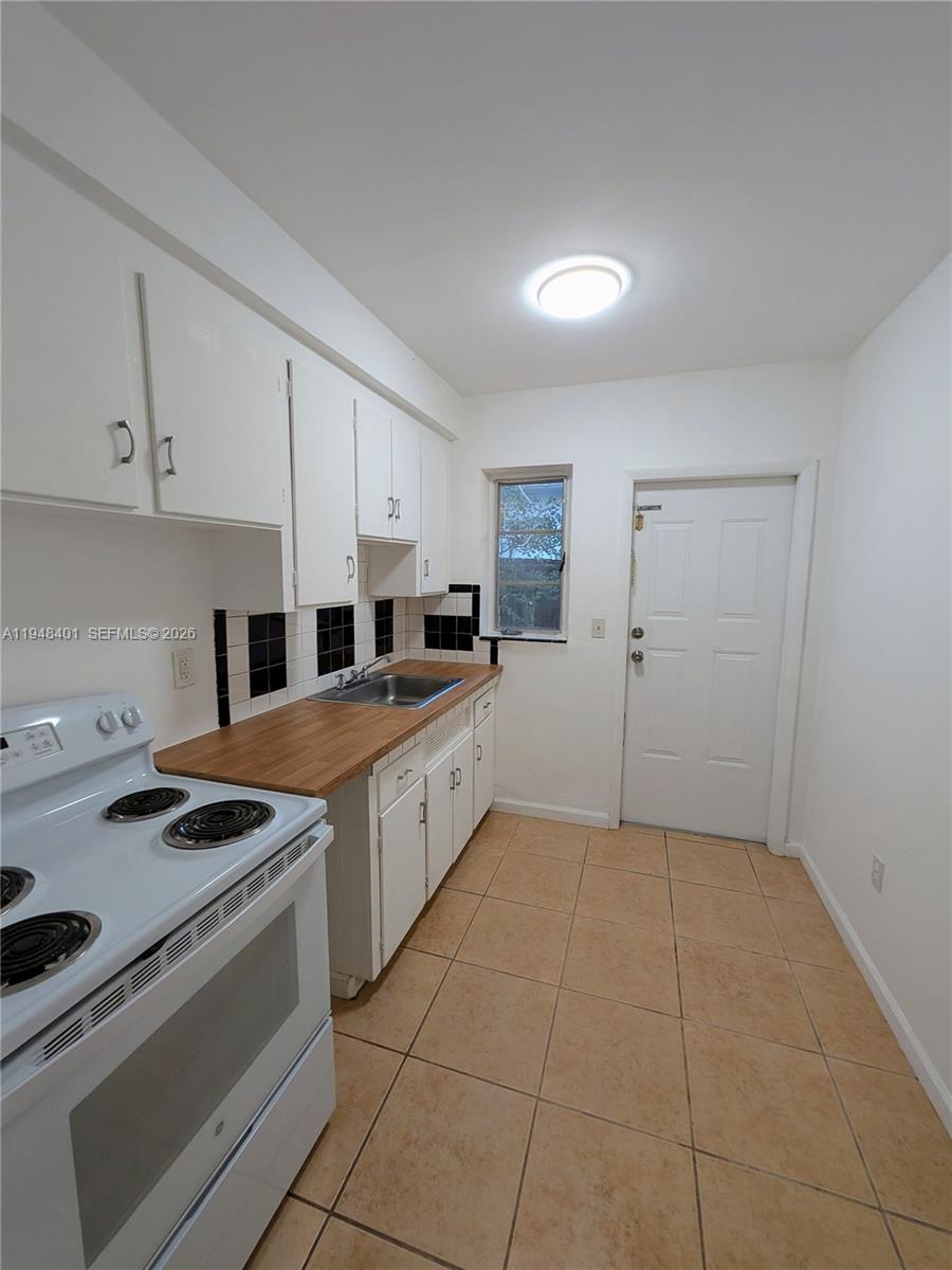 431 Northeast 64th Street, Unit 2 Miami, FL 33138 - Photo 4 of 8 a kitchen with a stove a sink and a refrigerator