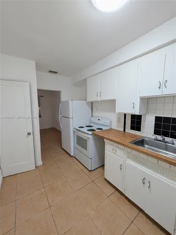 a kitchen with a stove a sink and a refrigerator