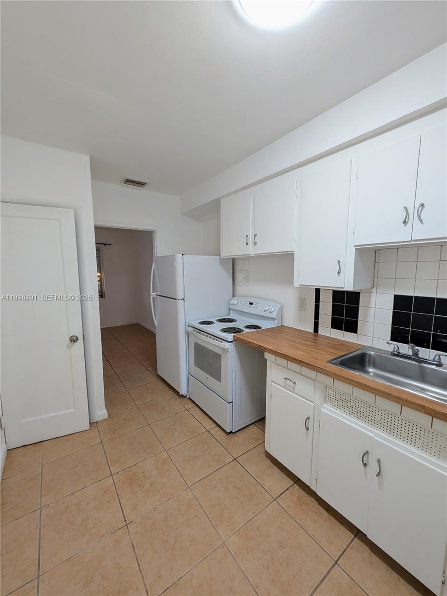 431 Northeast 64th Street, Unit 2 Miami, FL 33138 - Photo 5 of 8 a kitchen with a stove a sink and a refrigerator