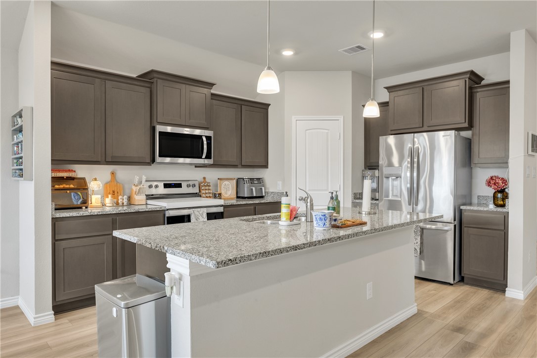 2016 Chief Street Bryan, TX 77807 - Photo 13 of 30 a kitchen with refrigerator a stove a sink cabinets and a wooden floor