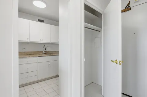 a bathroom with a granite countertop sink and cabinets