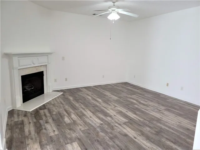 a view of empty room with fan and fireplace