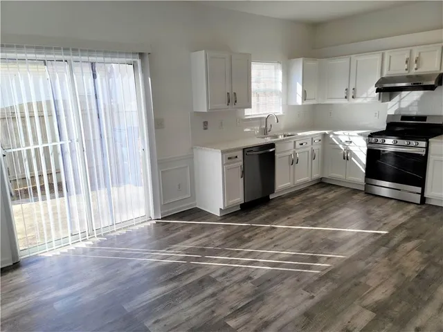 a kitchen with a stove a sink and a window