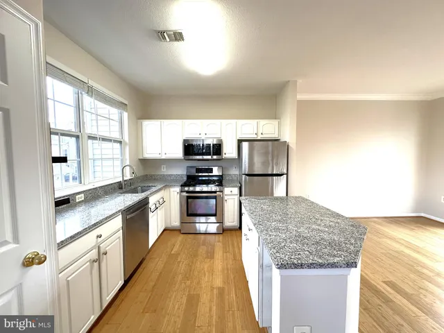a large kitchen with a stove a sink and a refrigerator