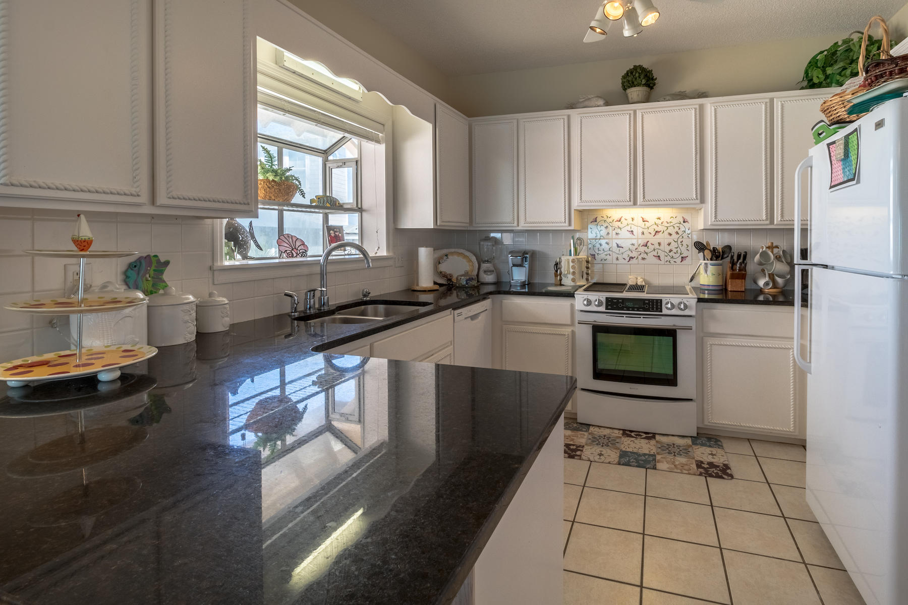 701 Eastern Lake Road Santa Rosa Beach, FL 32459 - Photo 28 of 45 a kitchen with stainless steel appliances granite countertop a sink stove and cabinets